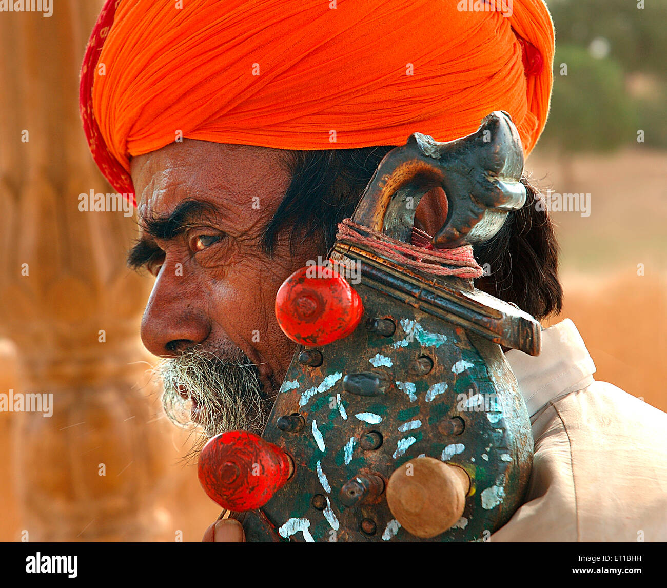 Old folk musician in orange turban playing sarangi ; Jaisalmer ; Rajasthan ; India MR#746B Stock Photo