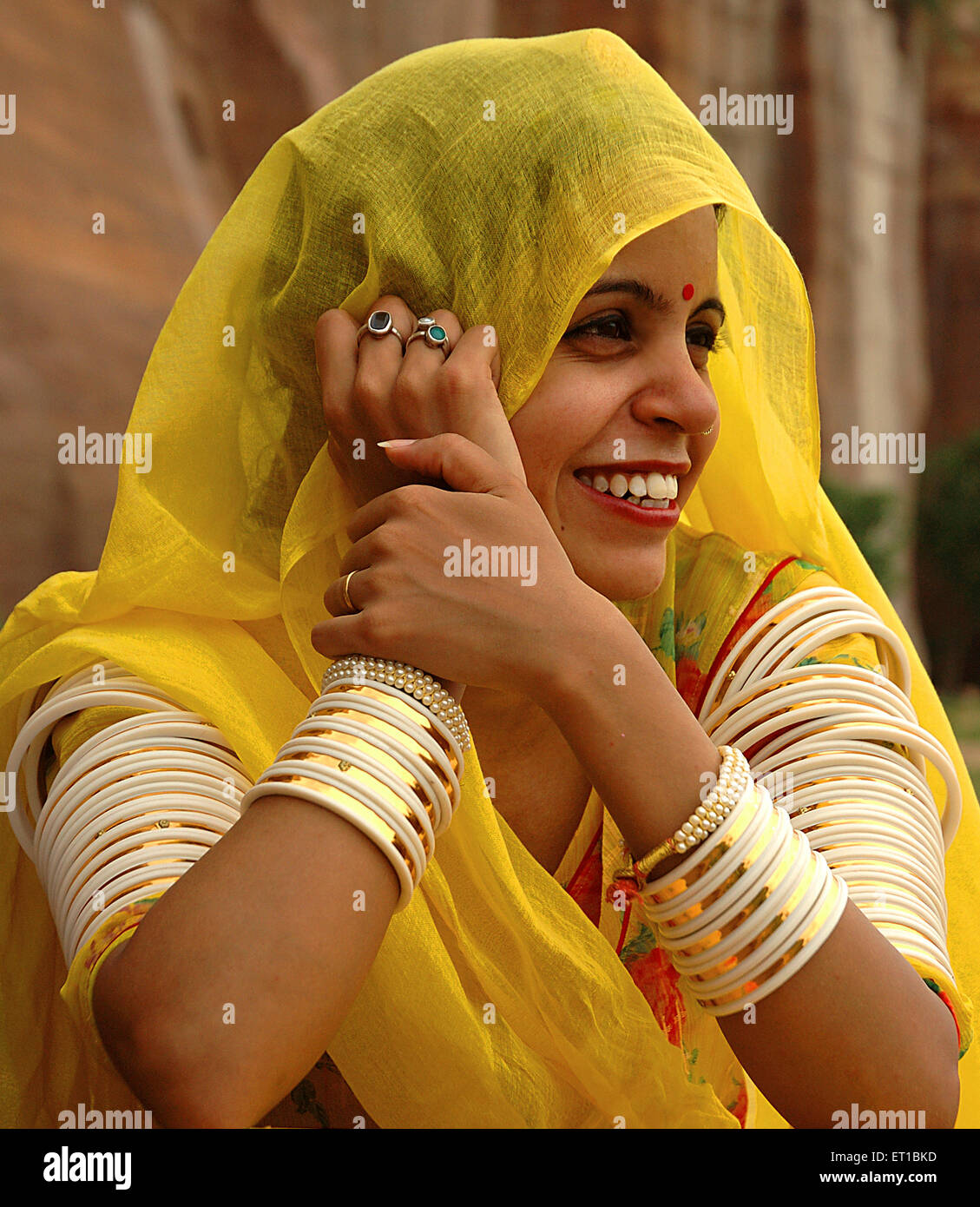 Rajasthani lady in yellow dress bangles in both hands ; Jodhpur ; Rajasthan ; India MR#746B Stock Photo