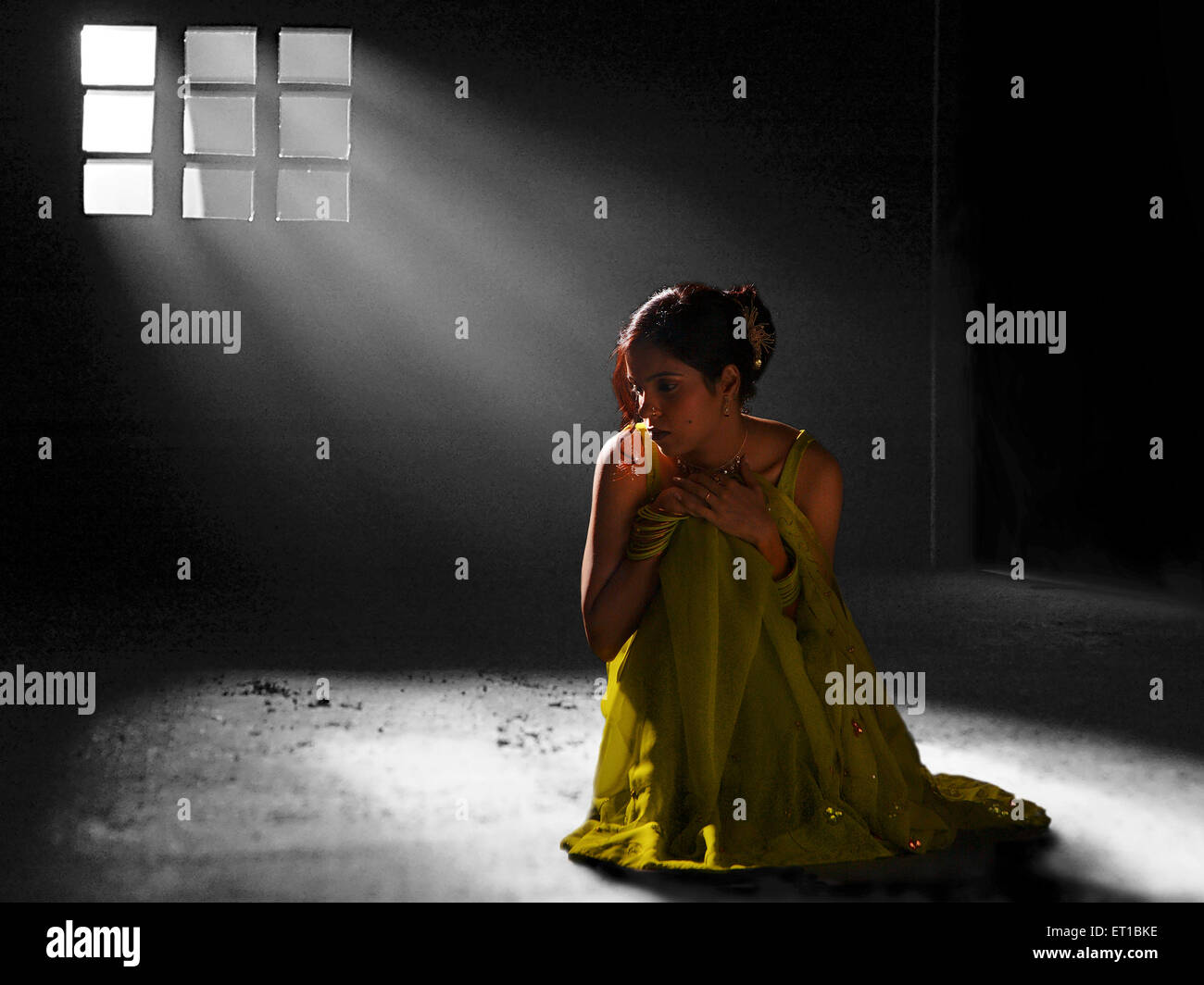 Lady sitting in light coming from window ; Jodhpur ; Rajasthan ; India MR#746B Stock Photo