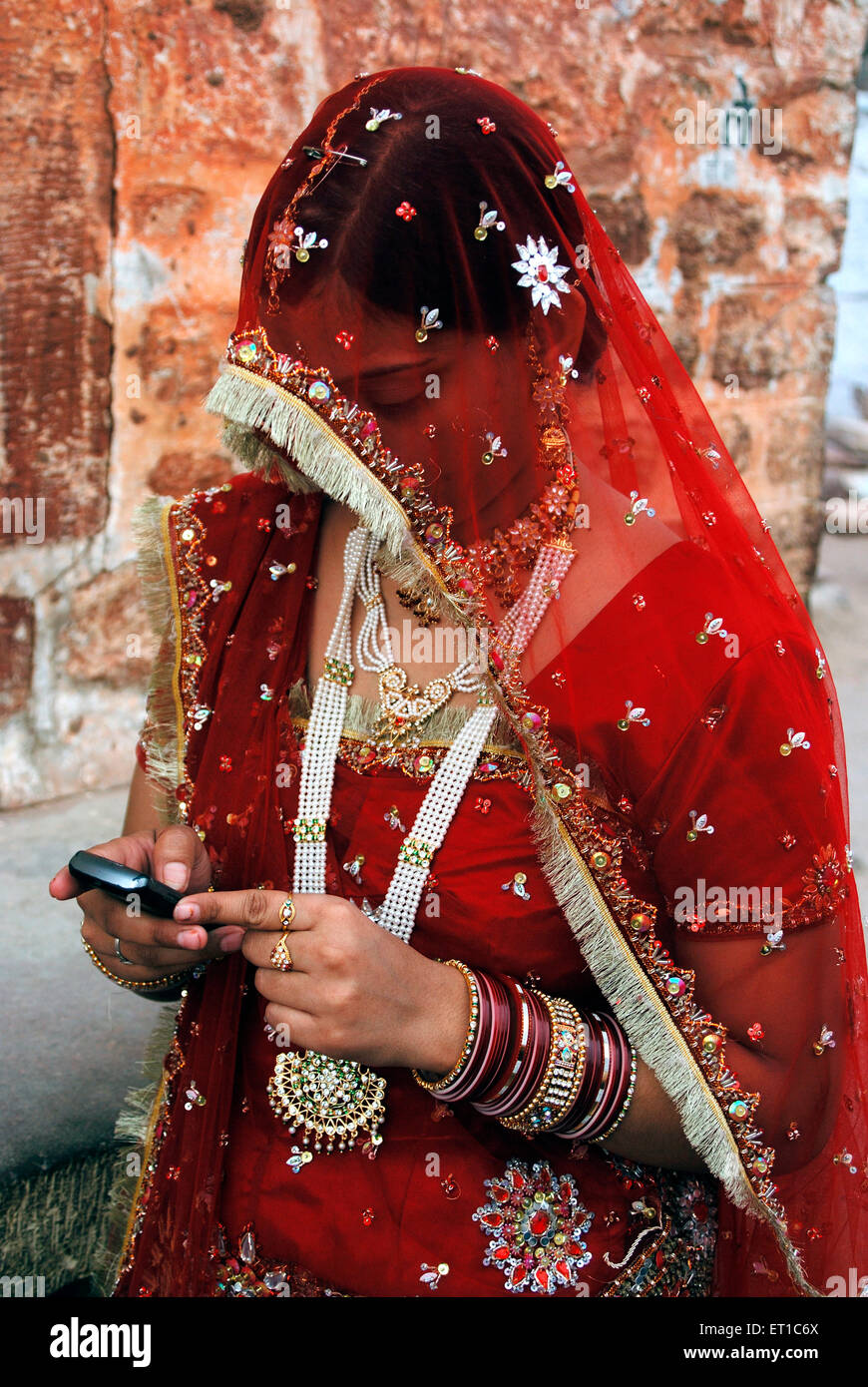 Rajasthani marwari woman in traditional dress holding mobile ; Jodhpur ; Rajasthan ; India NO MR Stock Photo