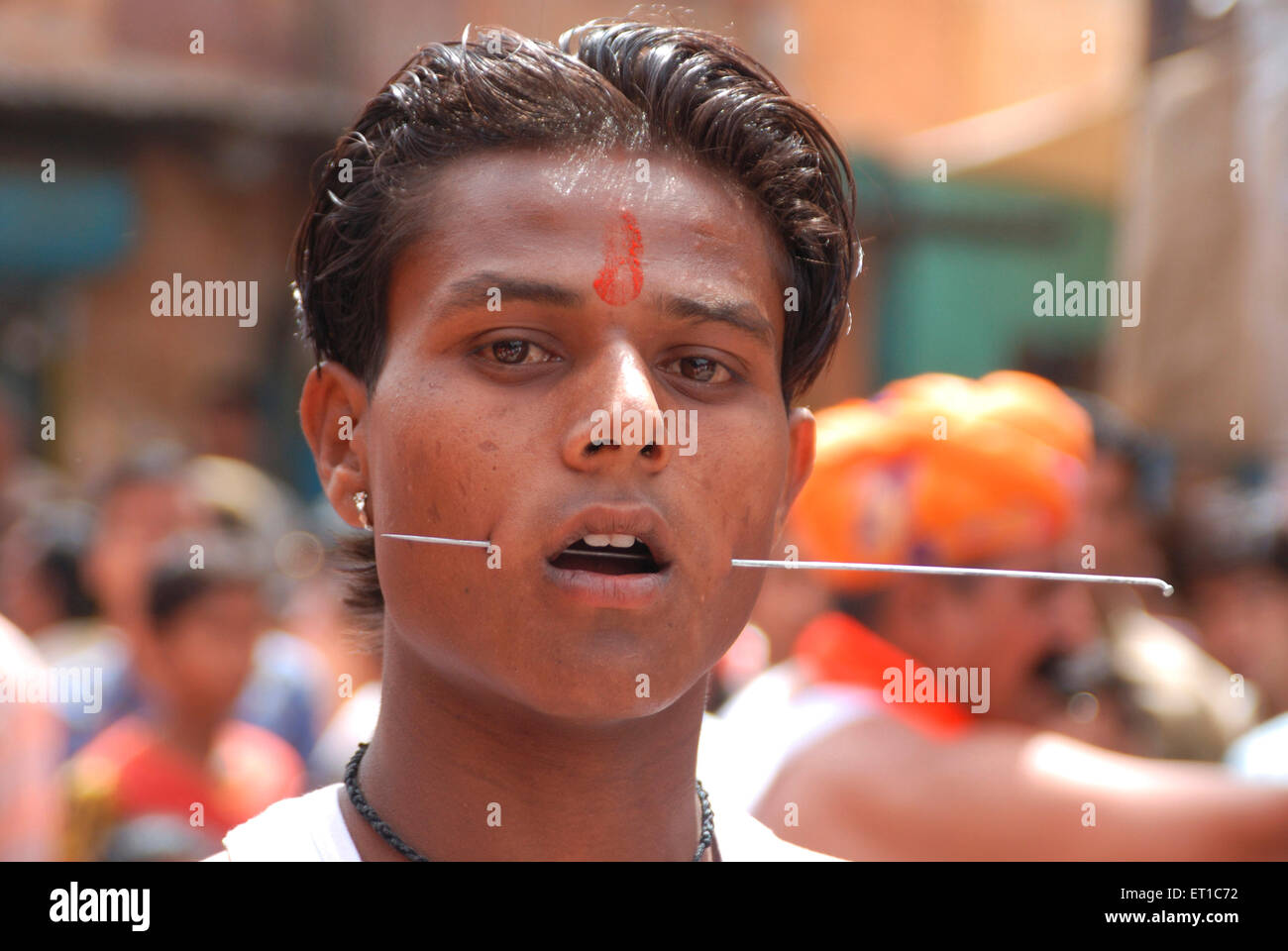 Iron rod inserted in cheeks of boy in Ramnavmi procession ; Jodhpur ; Rajasthan ; India NO MR Stock Photo