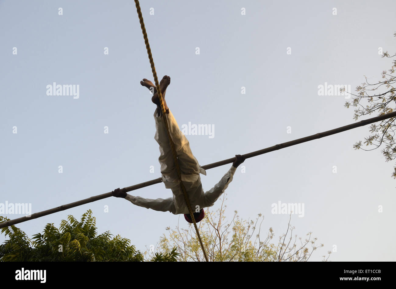 man performing acrobatic over a rope at Jodhpur Rajasthan India Stock Photo