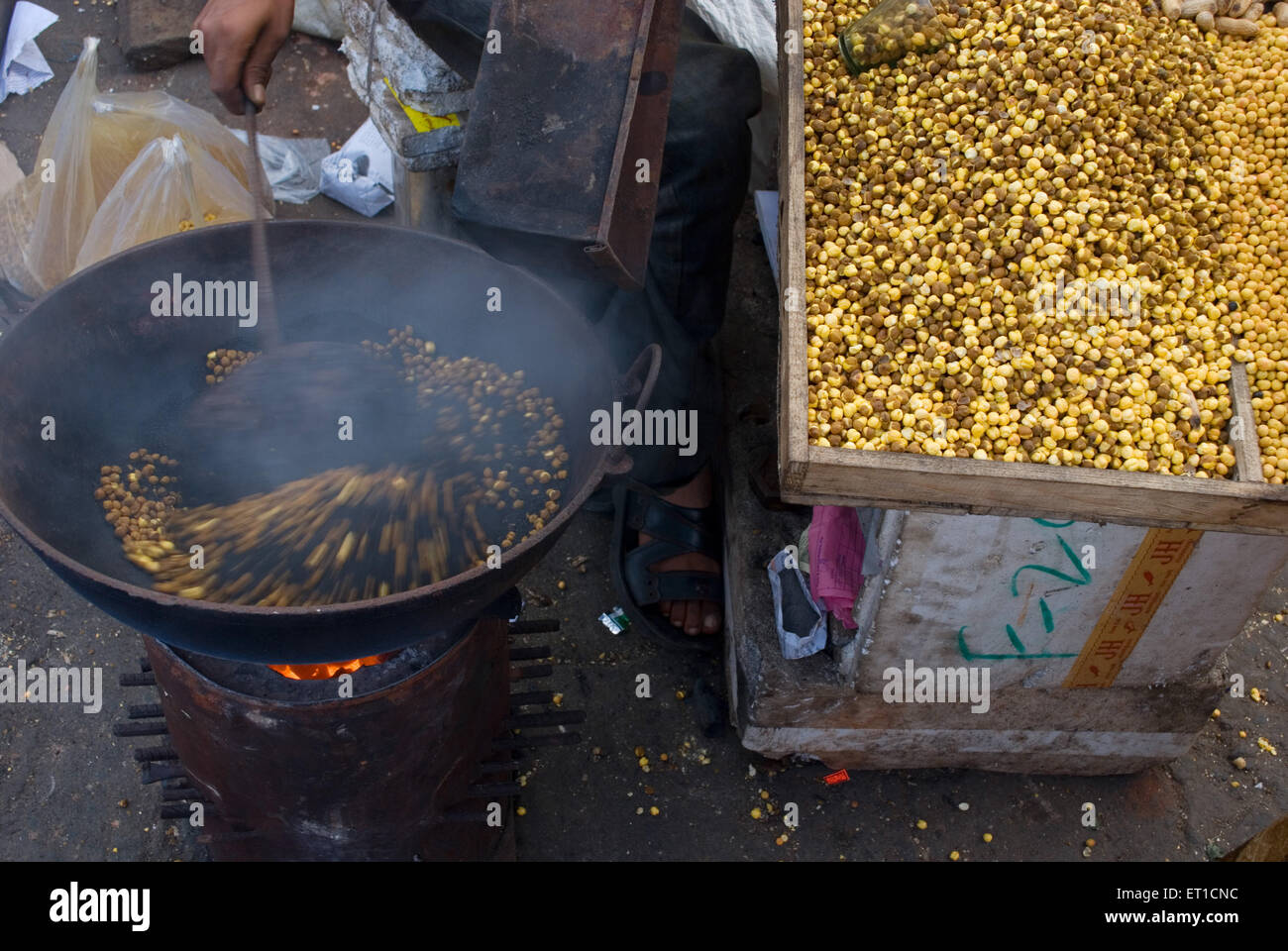 Man roasting gram ; Shillong ; Meghalaya ; India Stock Photo