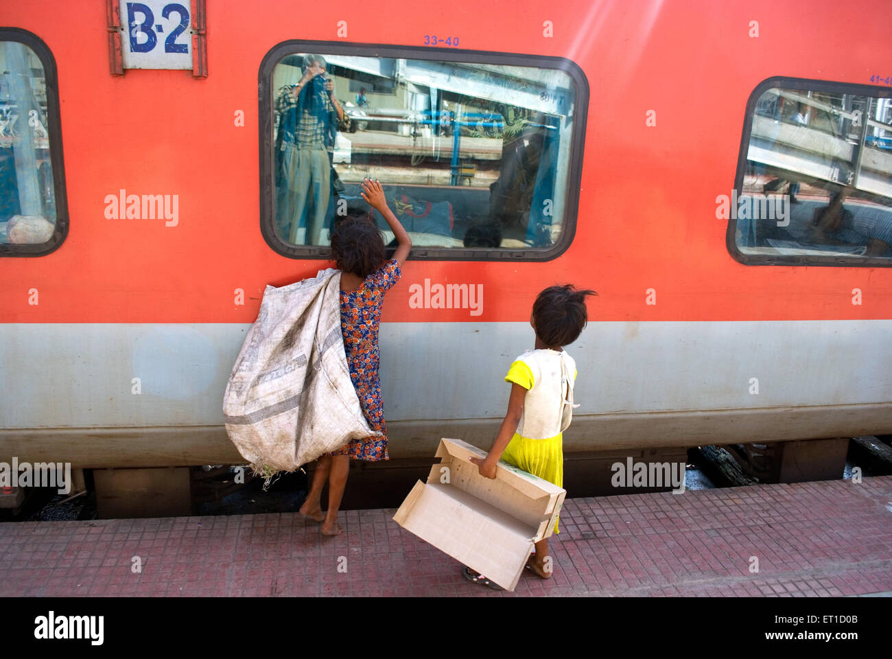 Rag picker children looking at window of rajdhani express train Guwahati ; Assam ; India Stock Photo