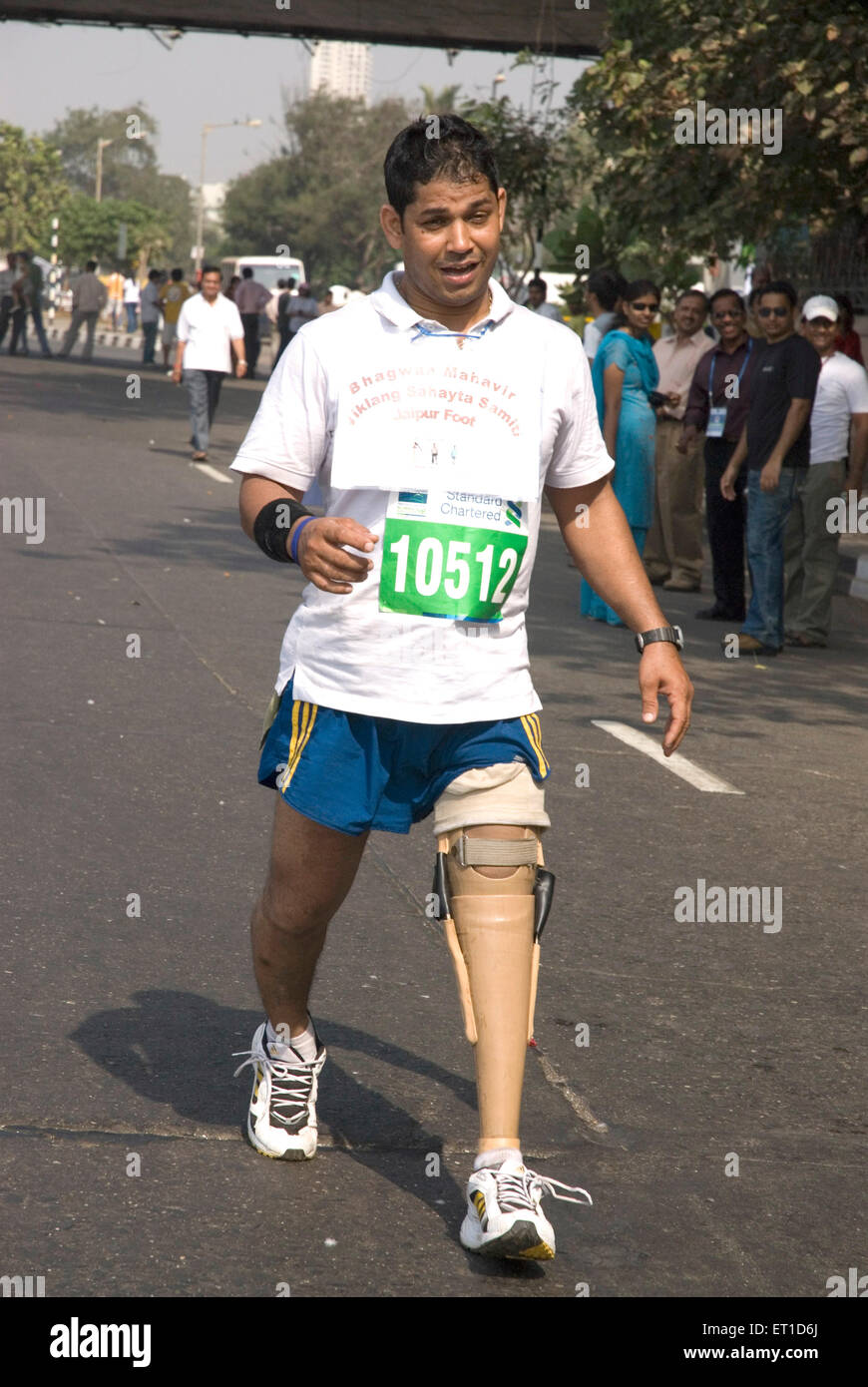Handicapped disabled man with prosthetic implant artificial leg running in marathon race ; Bombay ; Mumbai ; Maharashtra ; India ; Asia Stock Photo