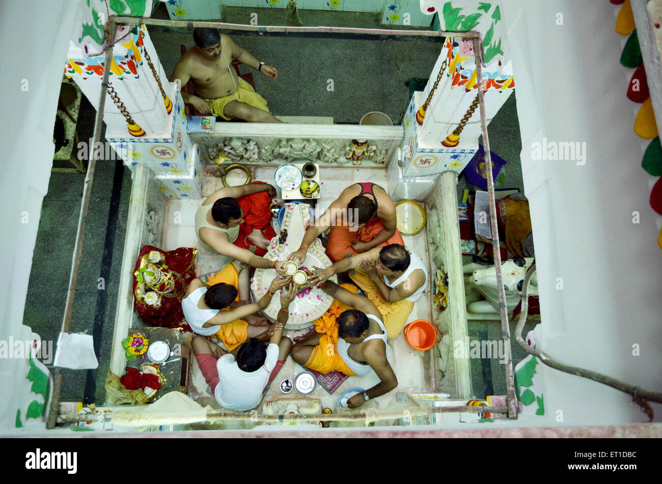 People performing Rudrabhishek around Shivling Pataleshwar temple Jodhpur Rajasthan India Asia Stock Photo