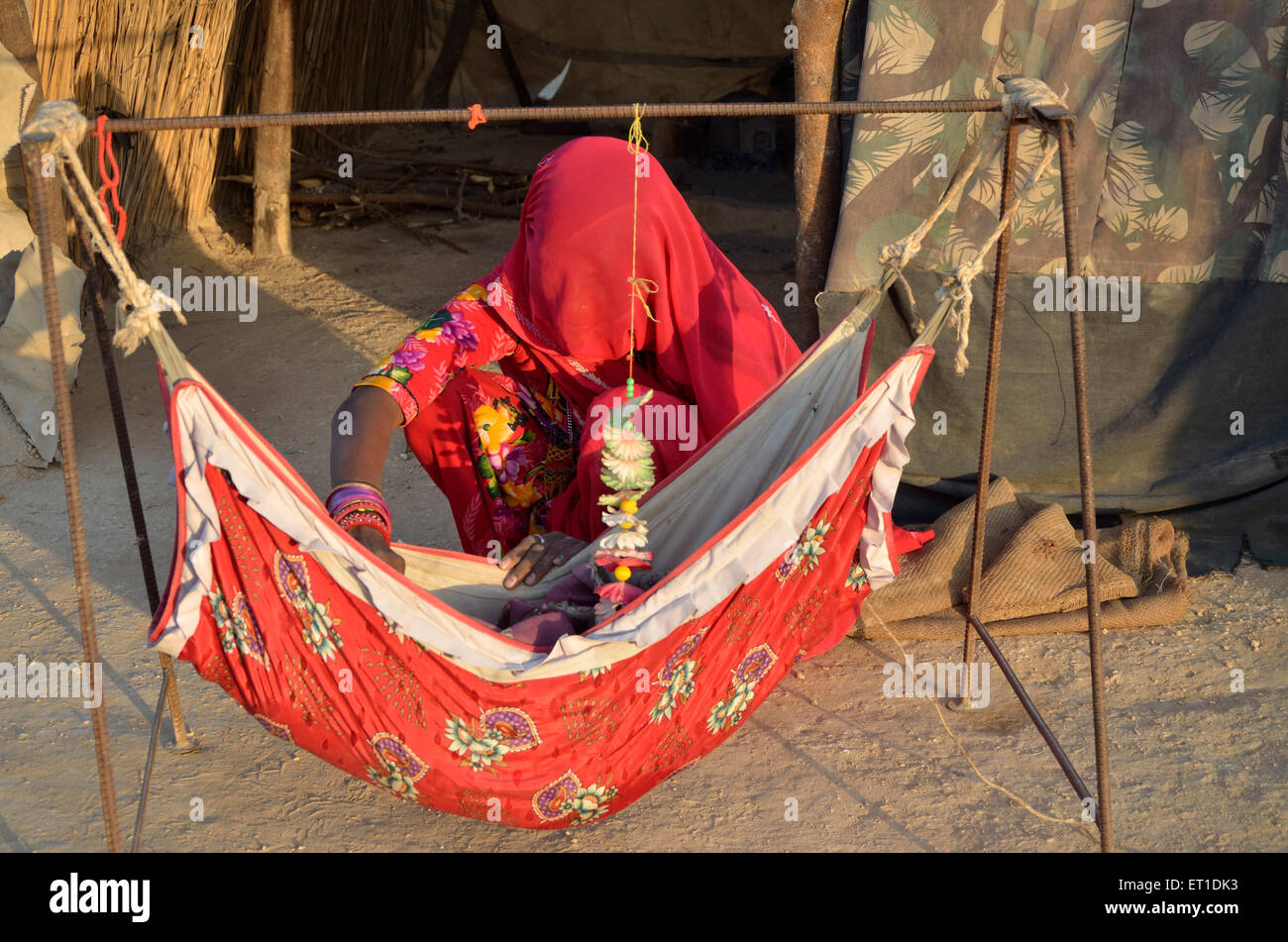 Woman ghunghat baby hammock Bikaner Rajasthan India Asia Stock Photo