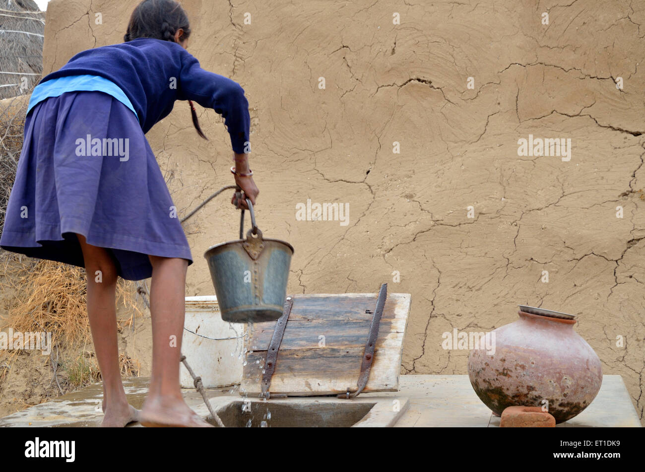 Girl in school uniform water in bucket Bikaner Rajasthan India Asia Stock Photo