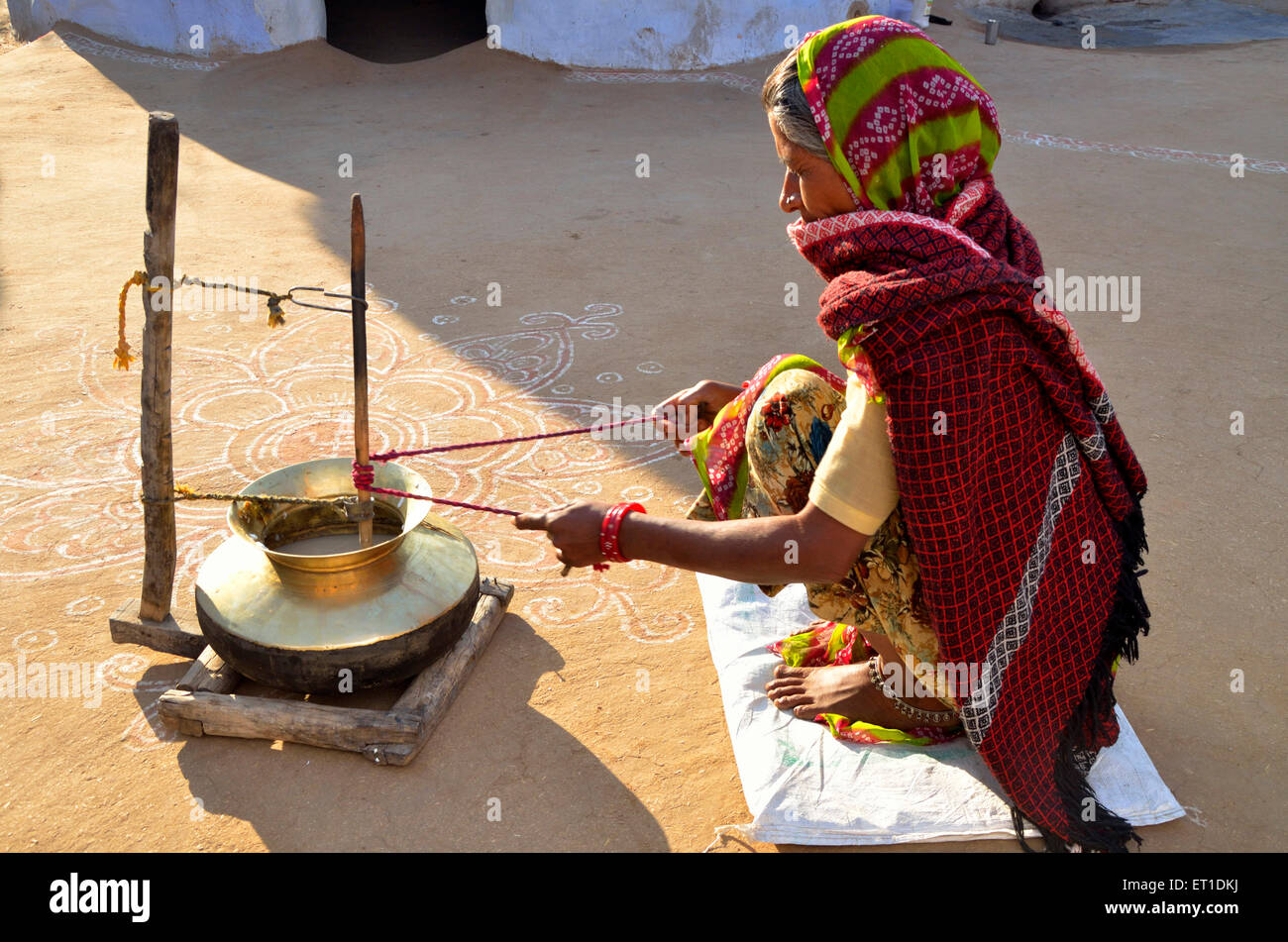 Woman churning curd into buttermilk Bikaner Rajasthan India Asia Stock Photo