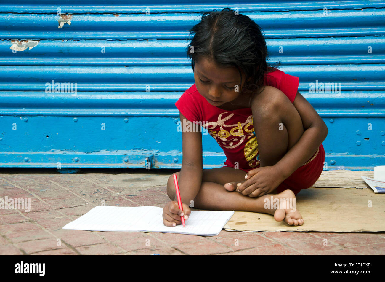 girl studying on footpath in Kolkata West Bengal India Asia Stock Photo