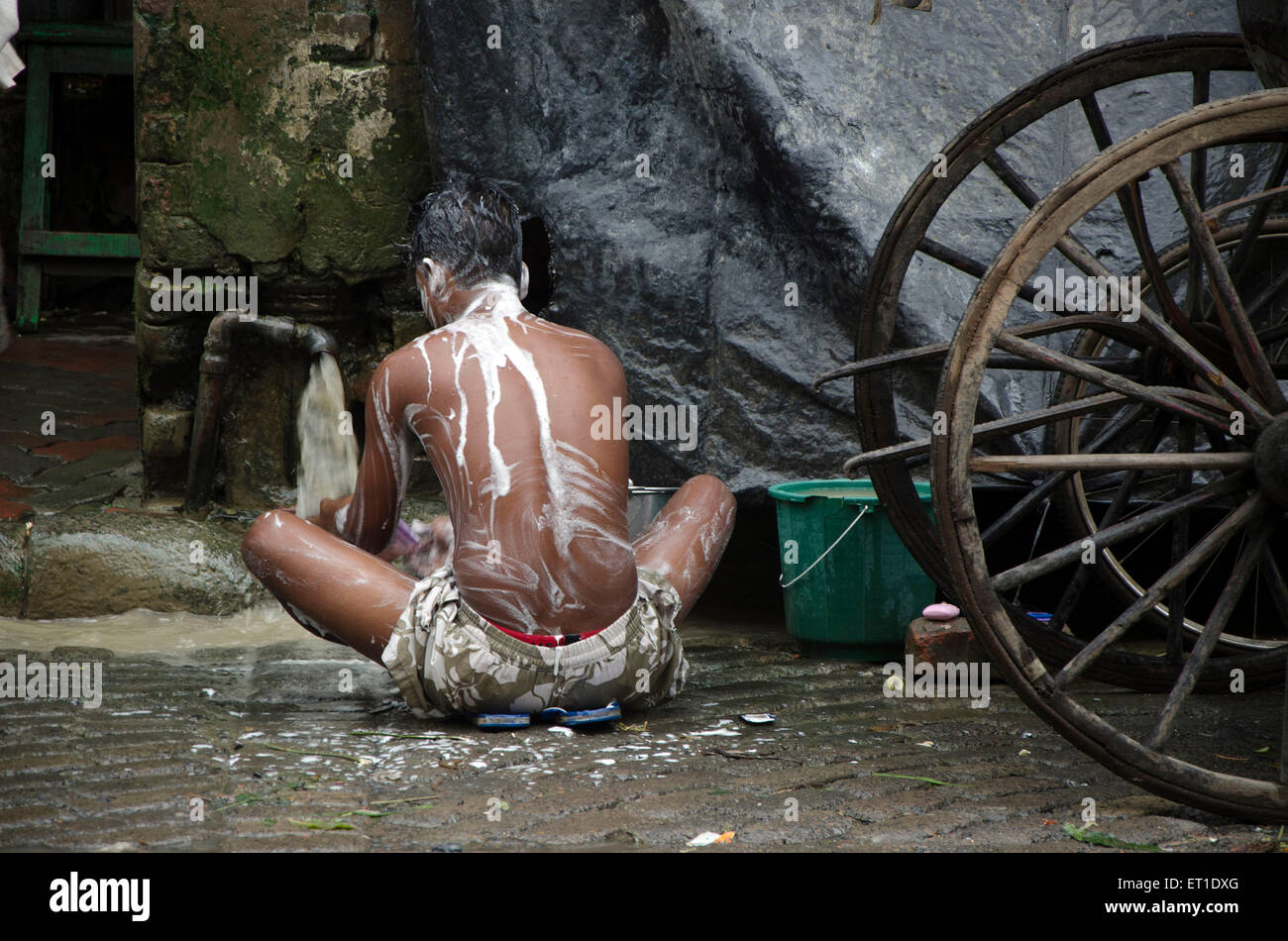 man bathing on street in Kolkata at West Bengal India Asia Stock Photo