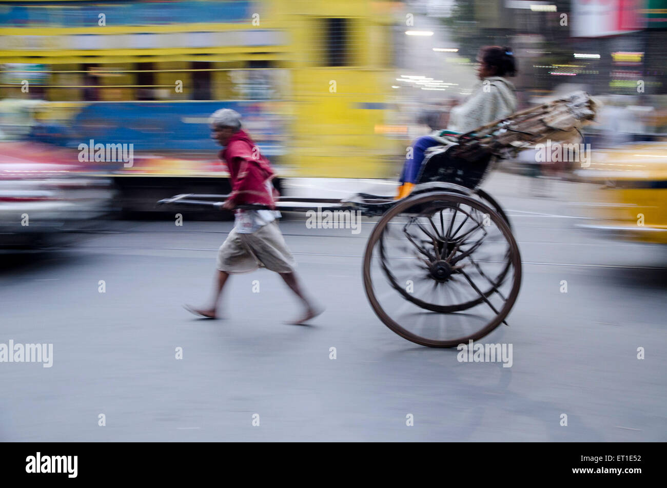Man pulling hand rickshaw on road Kolkata West Bengal India Asia Stock Photo