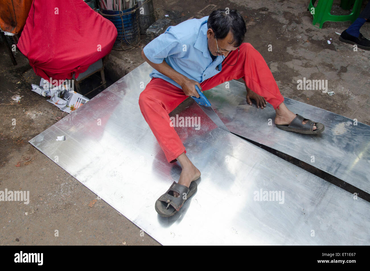 Worker cutting tin sheet Kolkata West Bengal India Asia Stock Photo