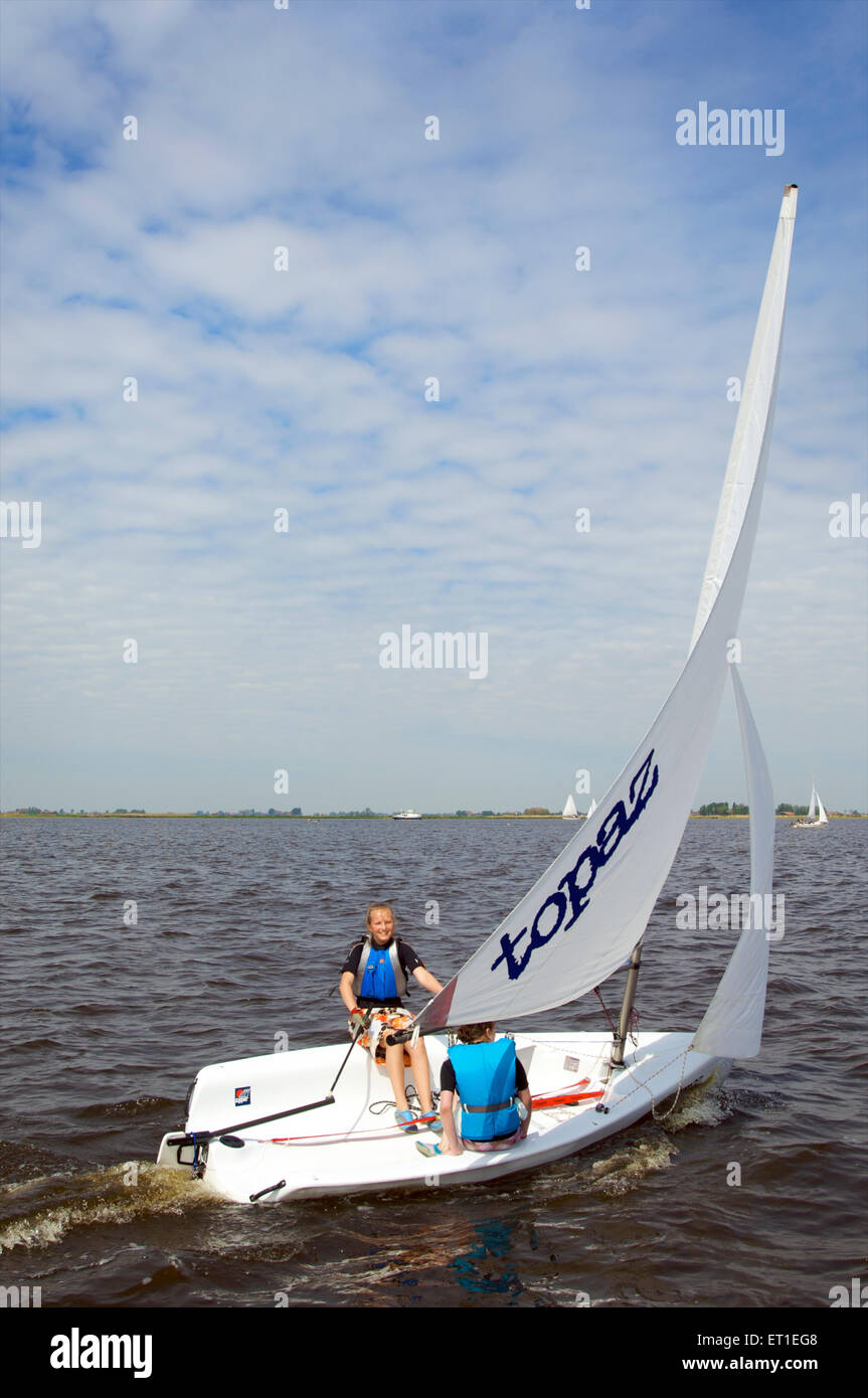 Two teenage girls sailing in a small sailing boat on the Frisian Lakes, the Netherlands Stock Photo