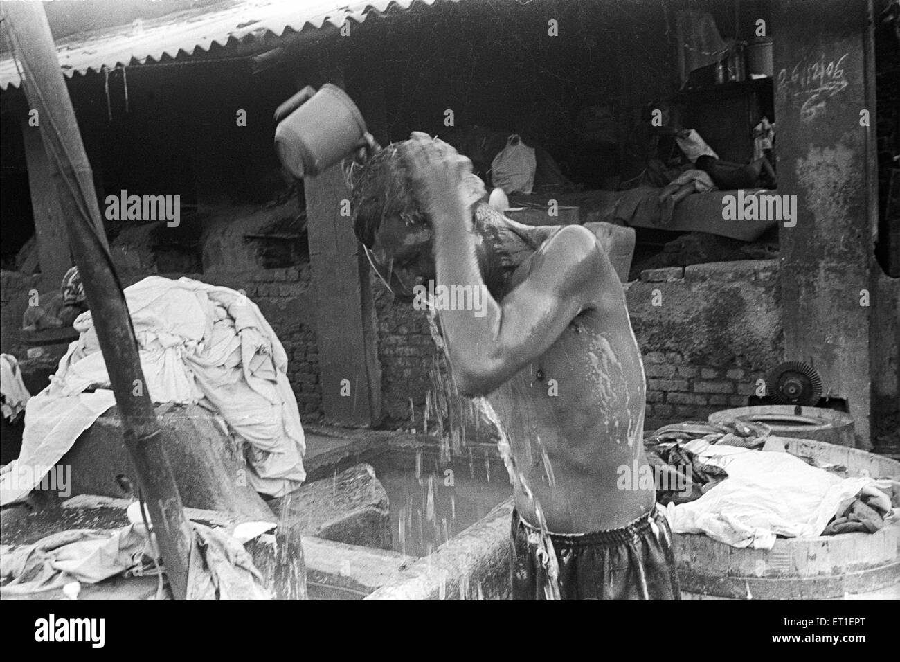 Washer man at dhobi ghat taking bath ; Mahalaxmi ; Bombay Mumbai ; Maharashtra ; India Stock Photo