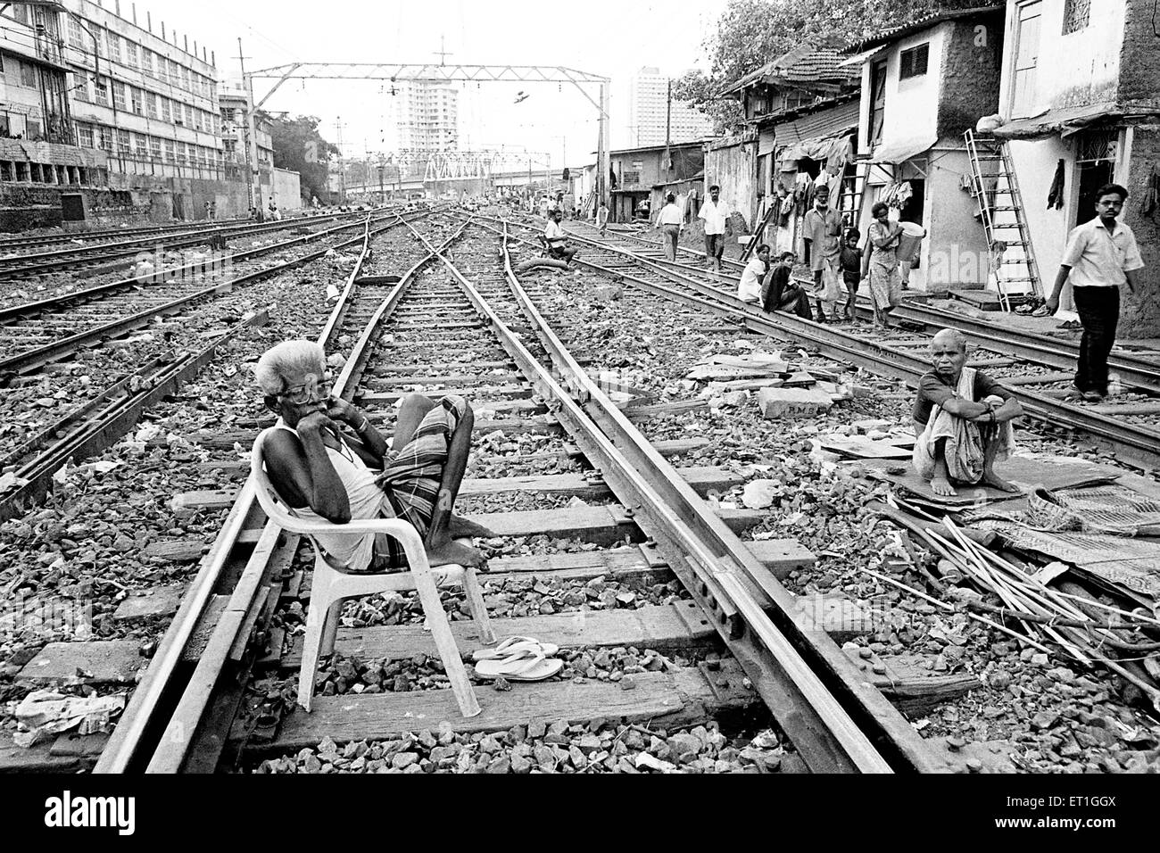 Old man sitting on chair on track at Wadala ; Bombay Mumbai ; Maharashtra ; India NO MR Stock Photo