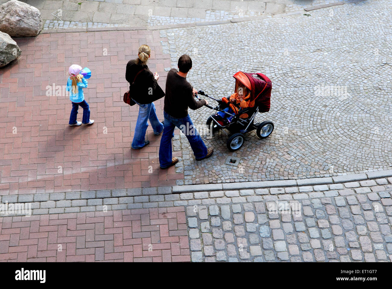 couple walking baby pram cobbled street, Berlin, Germany, German, Europe, European Stock Photo