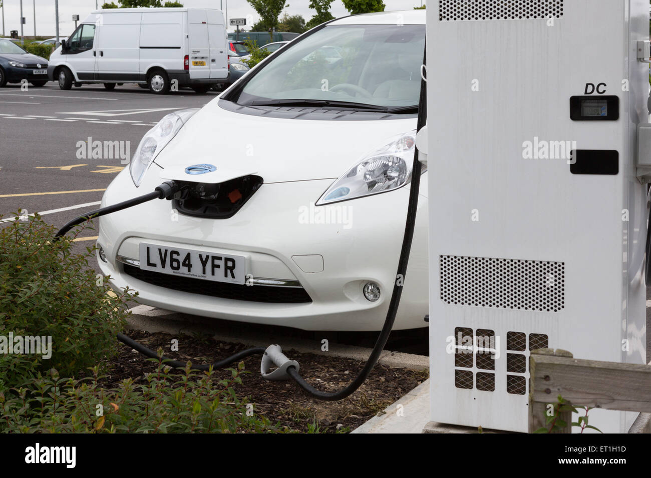 A Nissan Leaf electric car being re-charged at Cobham Services on the M25, Surrey, England, UK Stock Photo