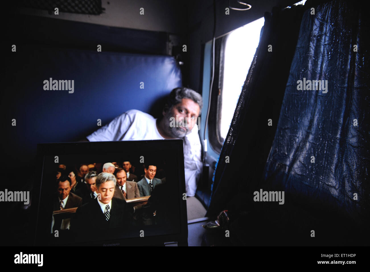 Man sitting in train, movie on laptop, Jammu, Kashmir, Jammu and Kashmir, Union Territory, UT, India, Asia, Asian, Indian Stock Photo