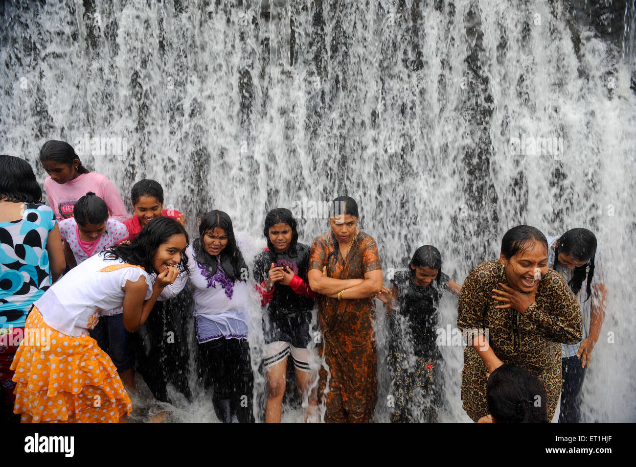 girls getting wet under waterfall, India, Asia, MR#400 Stock Photo