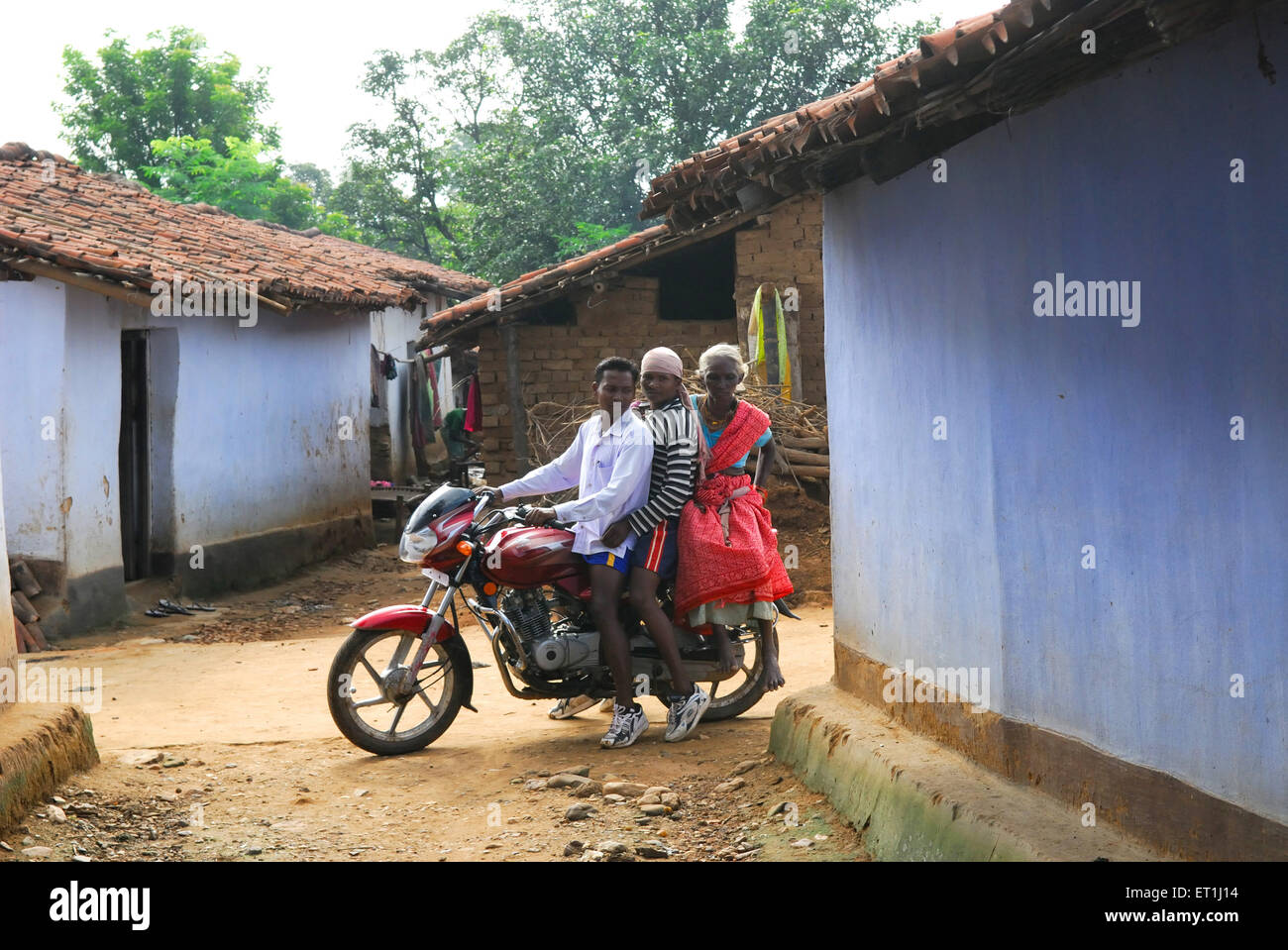 Ho tribes men carrying old midwife on bike ; Chakradharpur ; Jharkhand ; India NO MR Stock Photo