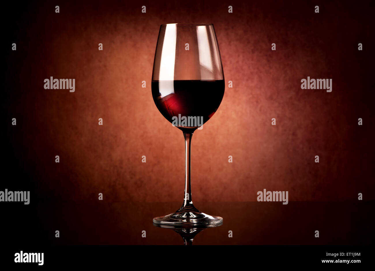 Red wine in glass on a vinous background Stock Photo