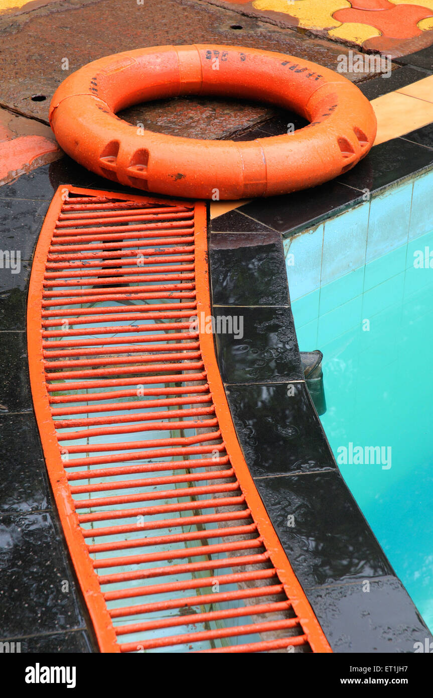 Rescue equipment lifeguard ring floating on iron grill of drain of swimming pool in surya shibir ; Pune ; Maharashtra Stock Photo