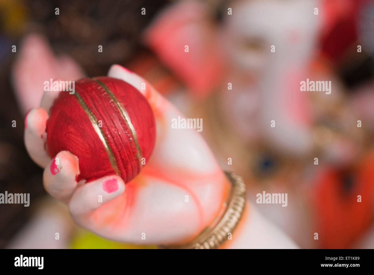 Red cricket ball in hands of Lord Ganesh Pune Maharashtra India Asia Sept 2011 Stock Photo