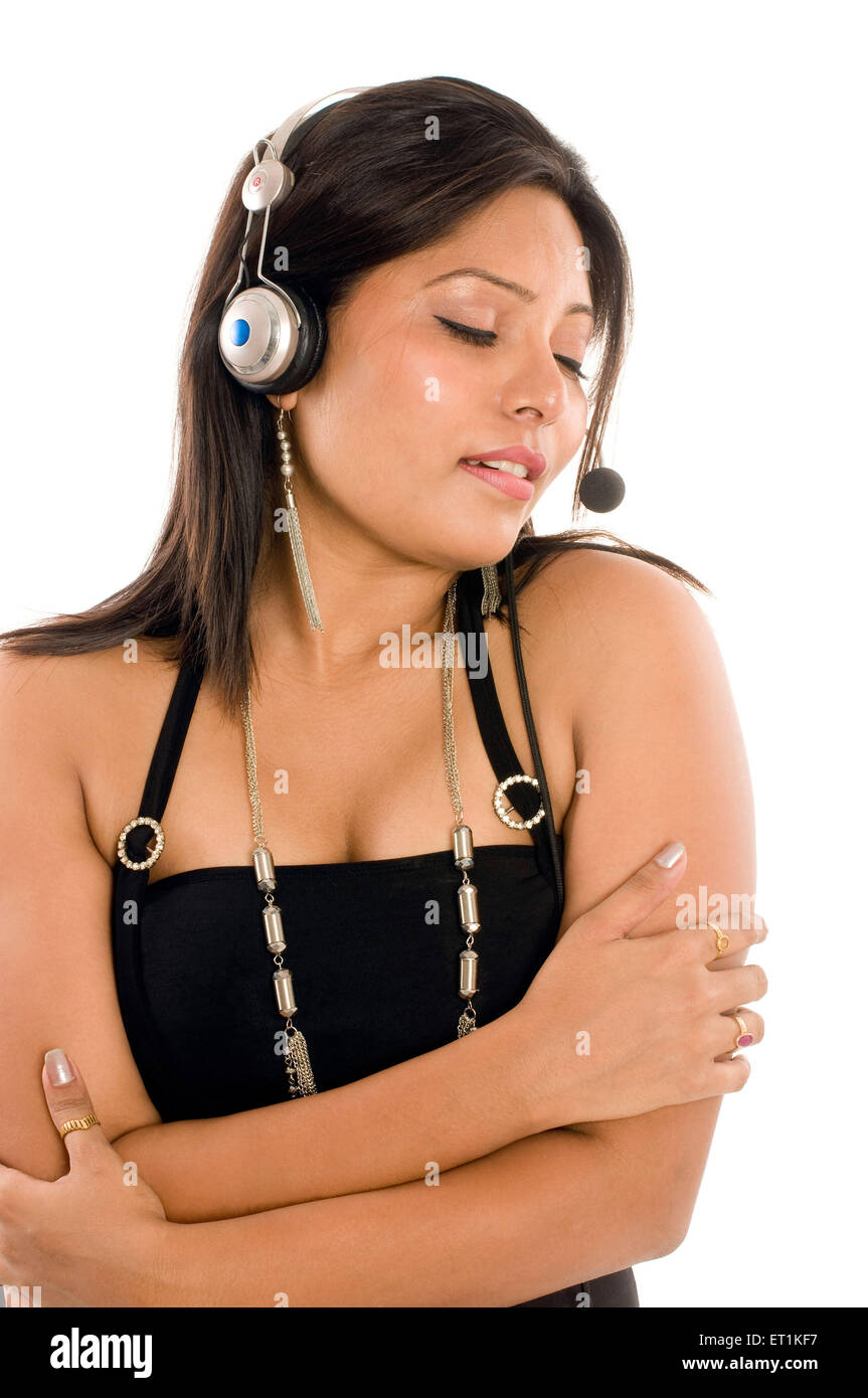 South Indian girl wearing black halter neck top and listening music in Pune at Maharashtra India Asia MR#686X Stock Photo