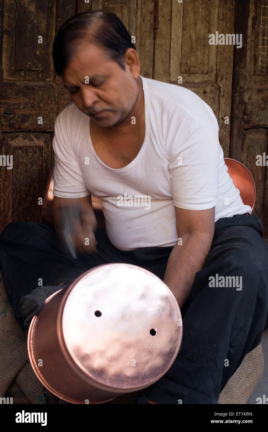 man hammering copper utensil Pune Maharashtra India Asia No MR Stock Photo
