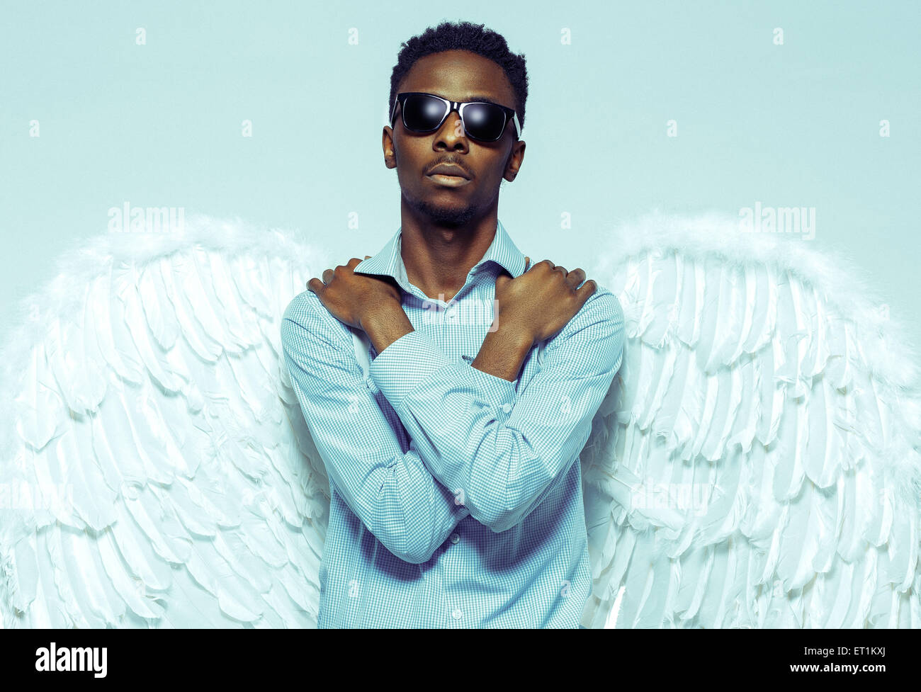 African American young man with angel wings in sunglasses Stock Photo