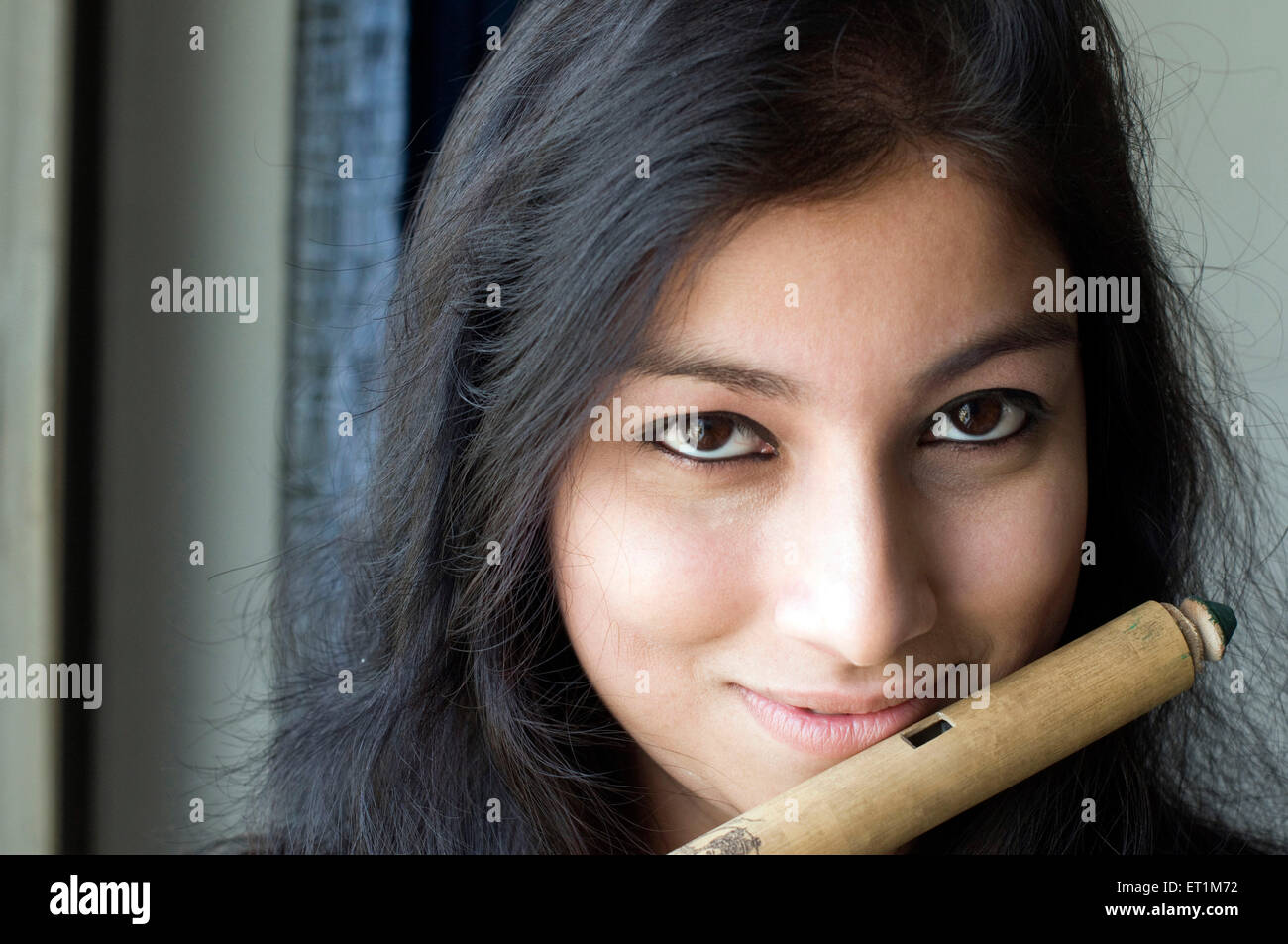 A face portrait of maharashtrian girl playing flute Pune Maharashtra India Asia MR # 686EE Stock Photo
