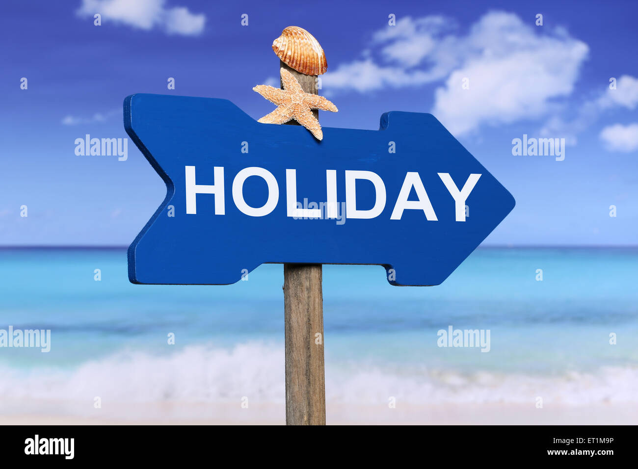 Holiday summer vacation on wooden arrow with beach and sea Stock Photo