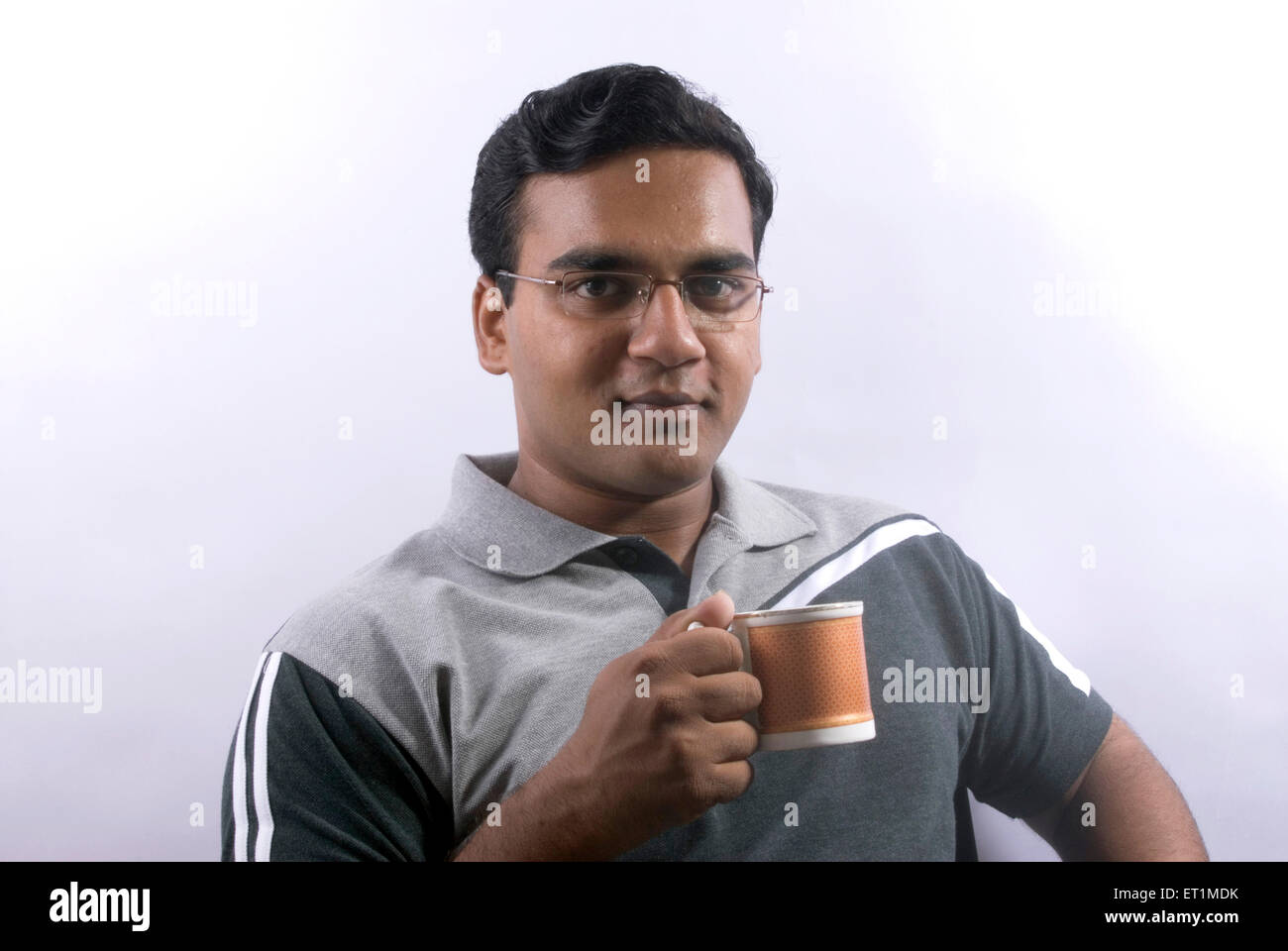 Young man drinking tea or coffee from mug ; India MR#556 Stock Photo