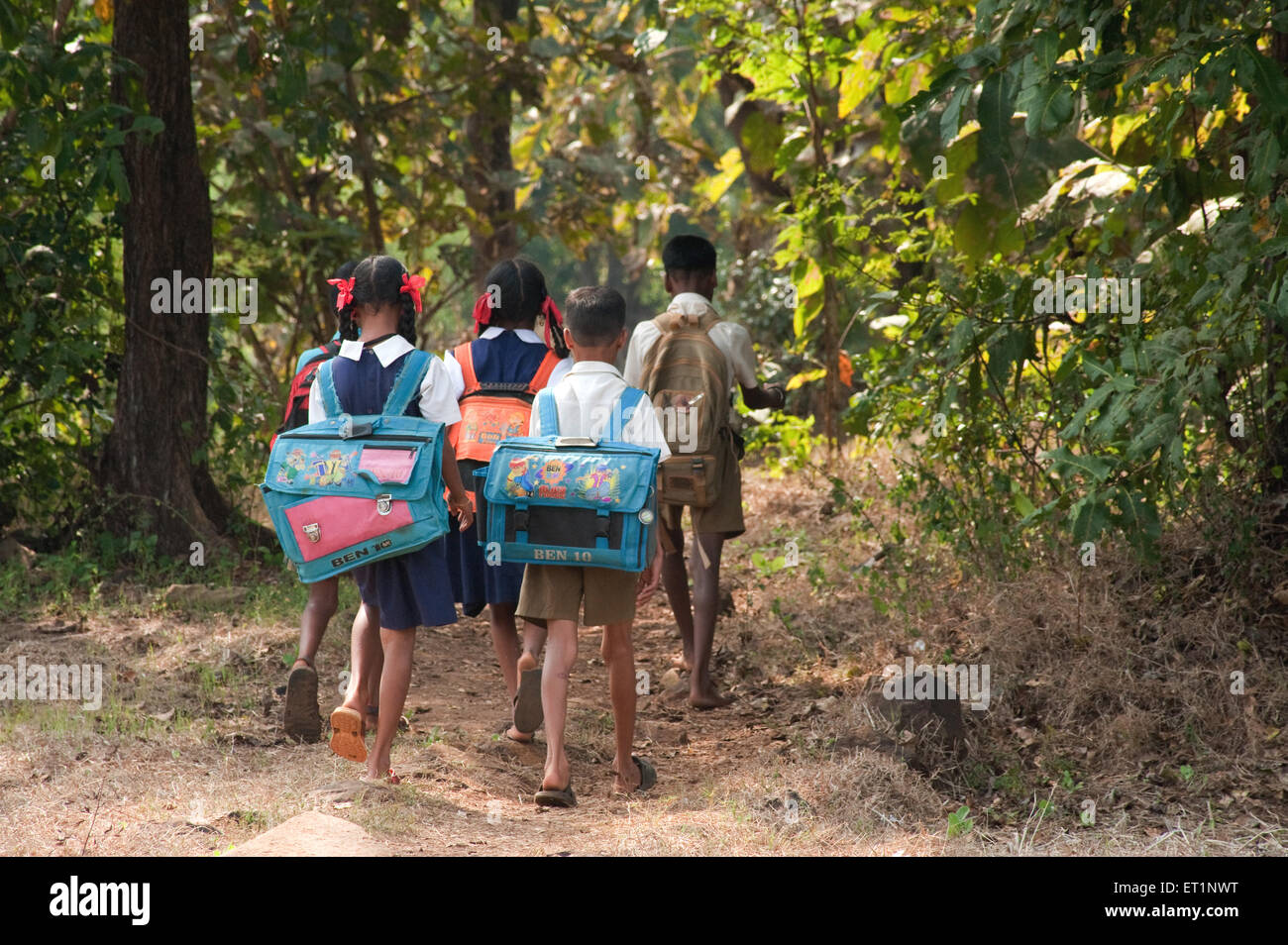 Students children boys girls walking to village school carrying heavy