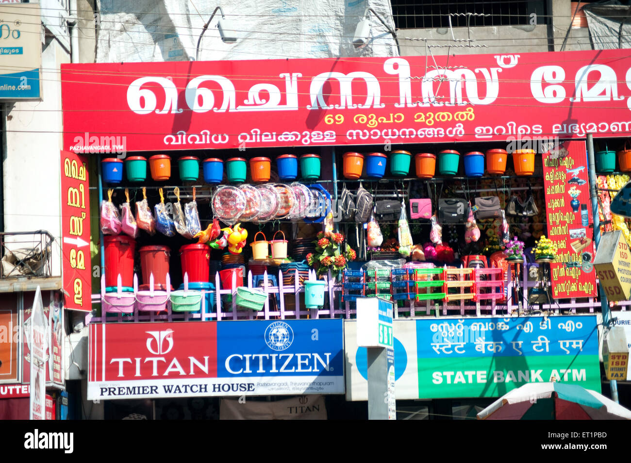 Shop selling plastic products ; Titan watches ; Citizen watches ; State Bank ATM ; Trivandrum ; Thiruvananthapuram ; Kerala ; India ; Asia Stock Photo