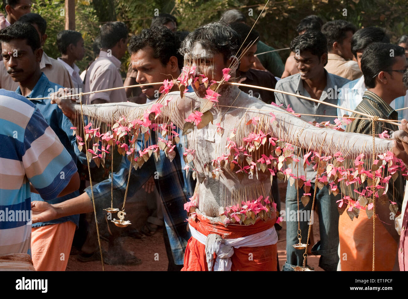 Man piercing spike through cheeks discharging vow in Thaipusam festival ; Kerala ; India NOMR Stock Photo