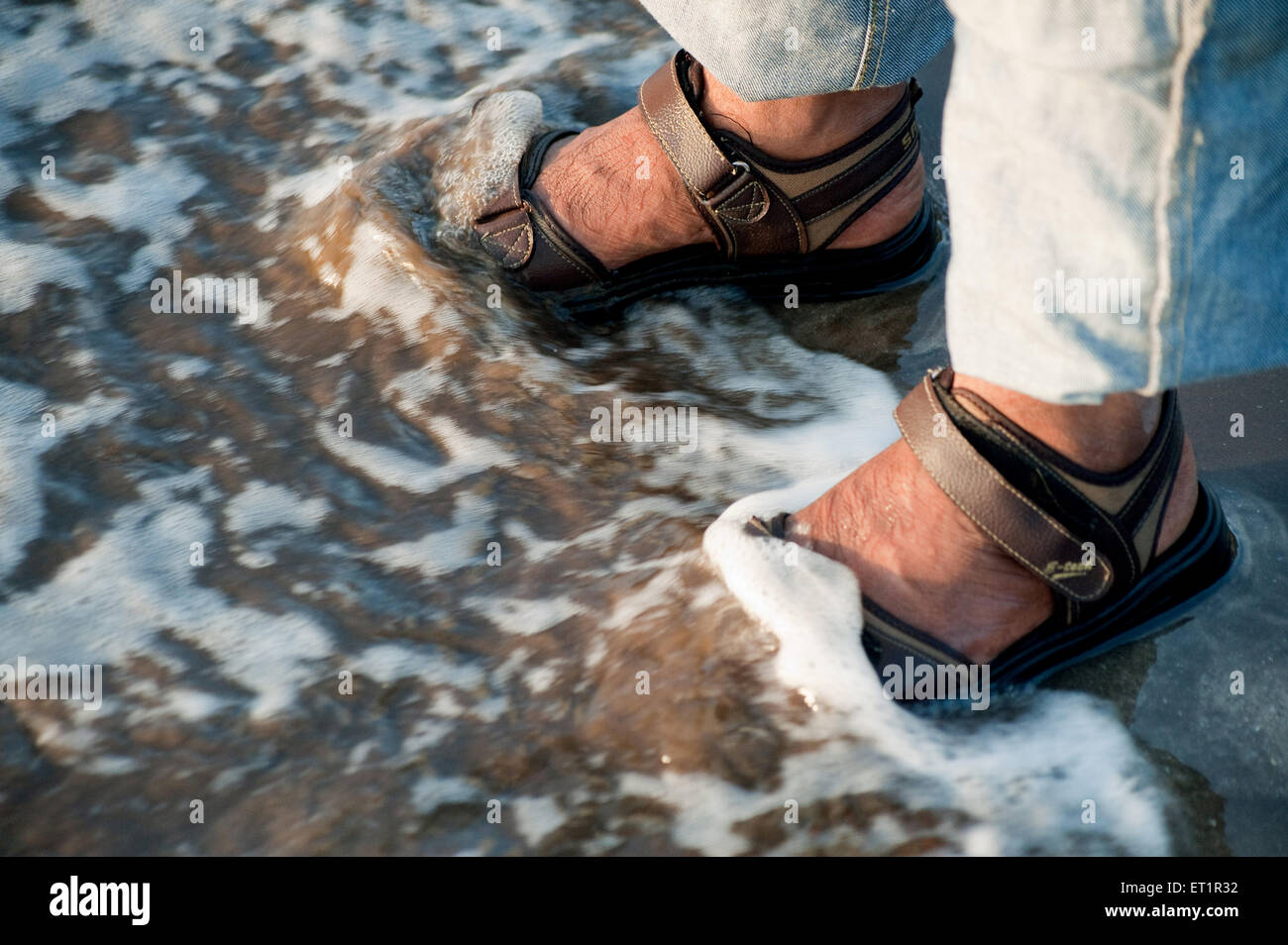 Sea waves or surf cracking on footsteps at nagaon beach ; Alibag ; Maharashtra ; India Stock Photo