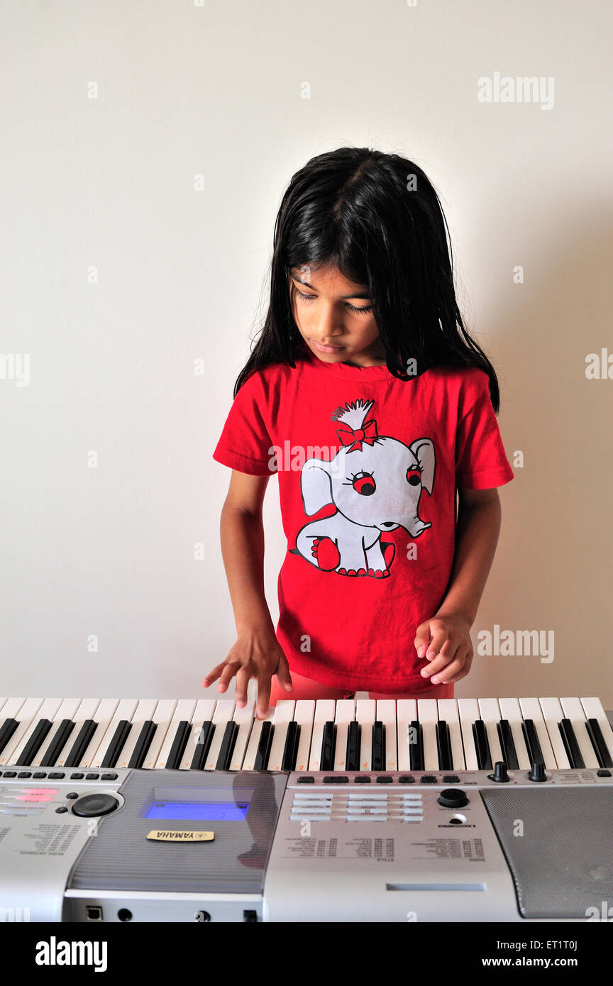 girl child playing electronic musical instrument synthesizer MR#556 Stock Photo