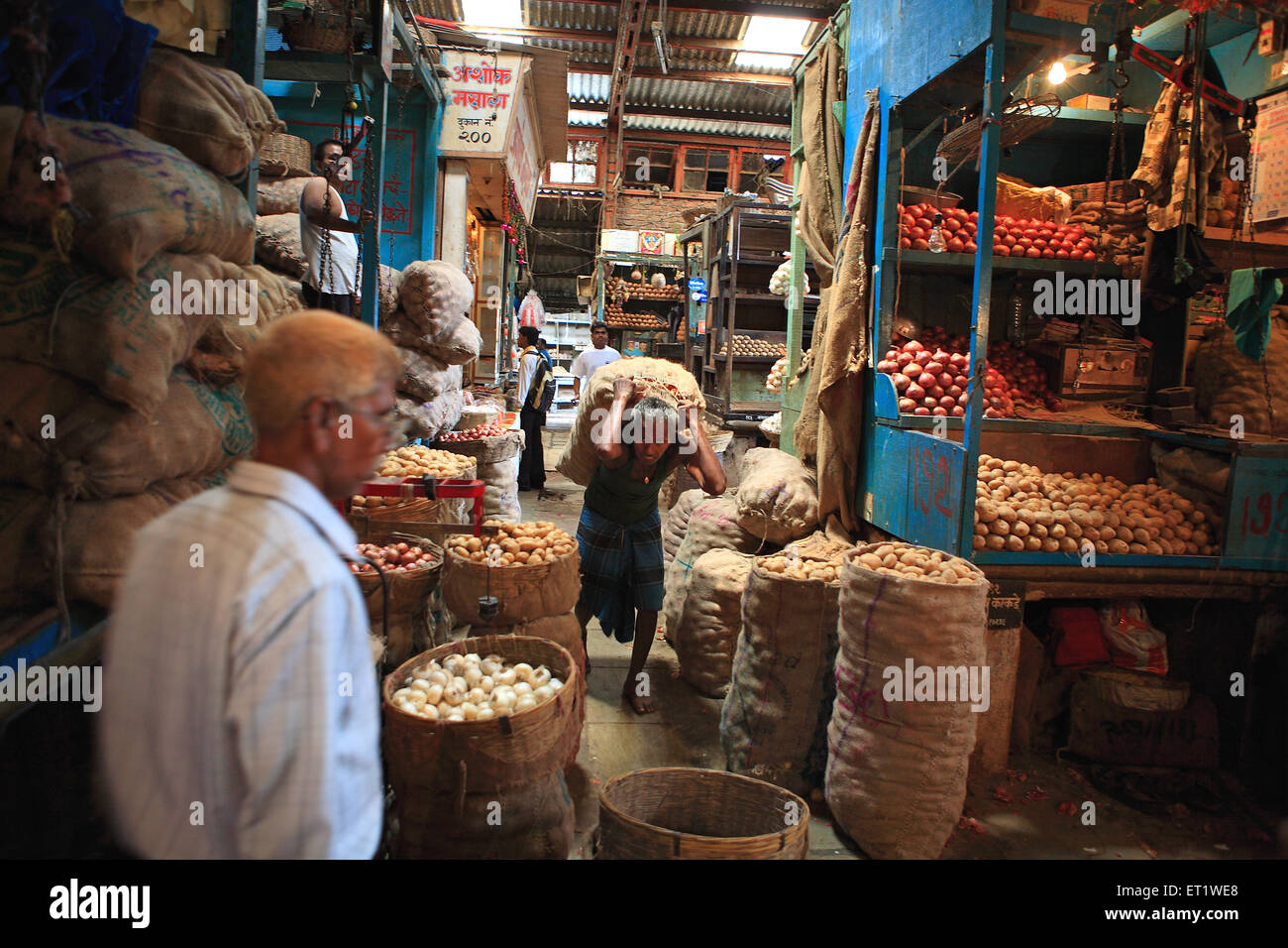 Labourer carrying a sack of onions ; Dadar vegetable market ; Bombay