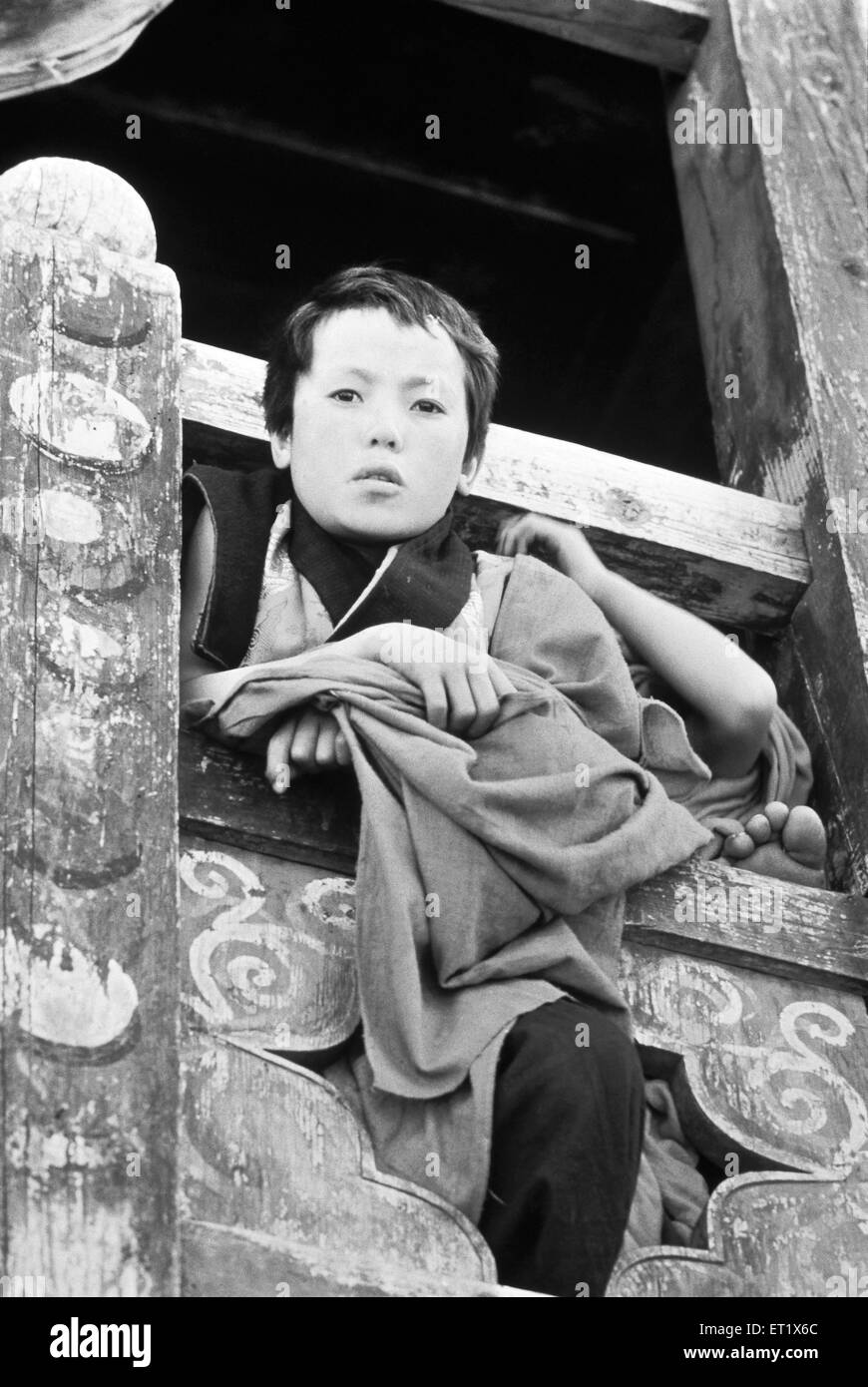 Young monk peep out a window in the monastery at Paro ; Bhutan ; Asia ; old vintage 1900s picture Stock Photo