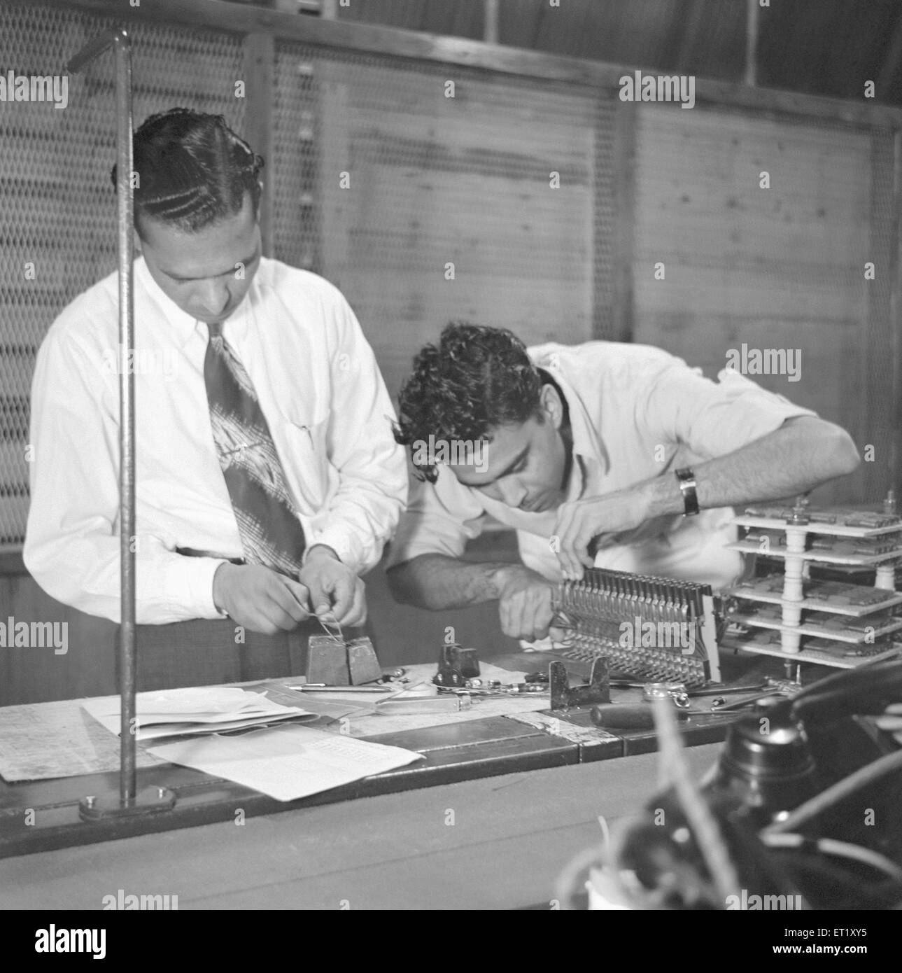 Men working in the telephone factory ; manufacturing of telephone instruments at Bangalore ; Karnataka ; India ; year 1950 ; Asia ; old vintage 1900s Stock Photo