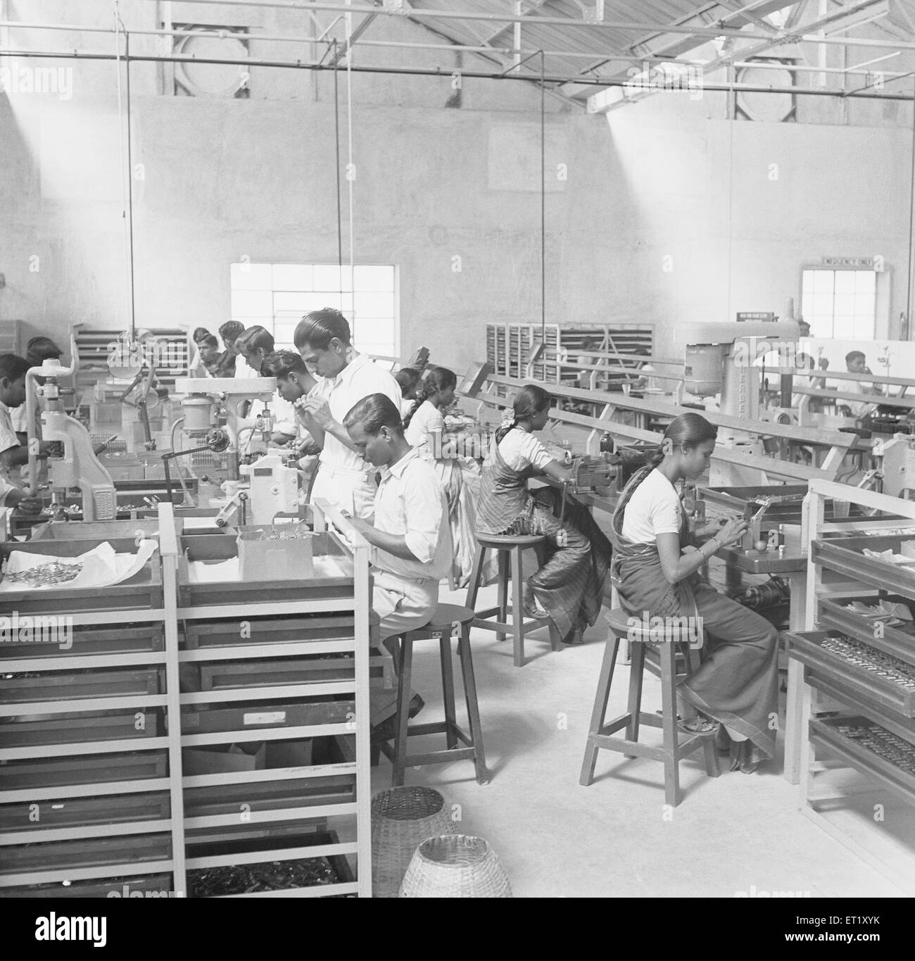 Workers at assembly line in telephone factory manufacturing of telephone instruments at Bangalore Karnataka India, 1950s, Asia ; old vintage 1900s Stock Photo
