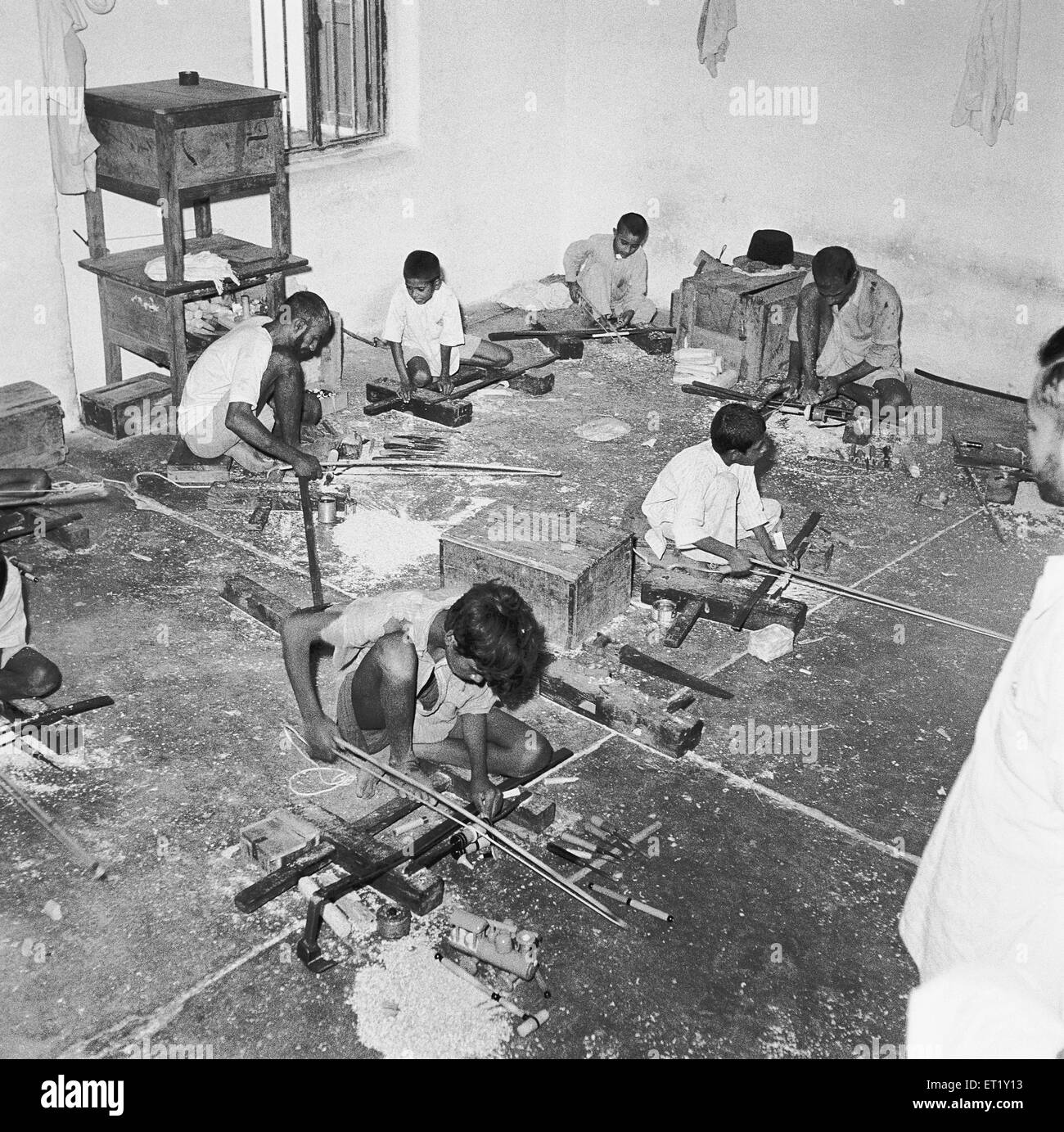 Young boys using portable rotating lathe for wood ; Channapatna ; Karnataka ; India ; Asia ; old vintage 1900s Stock Photo