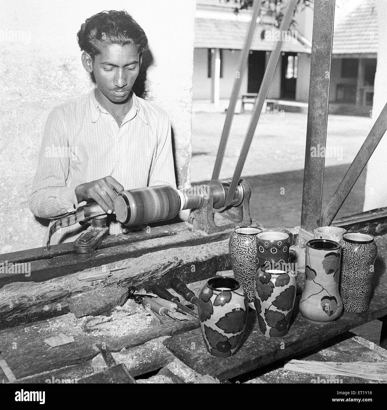 Man using portable rotating lathe painting lacquer toys ; Channapatna ; Karnataka ; India ; Asia ; old vintage 1900s Stock Photo