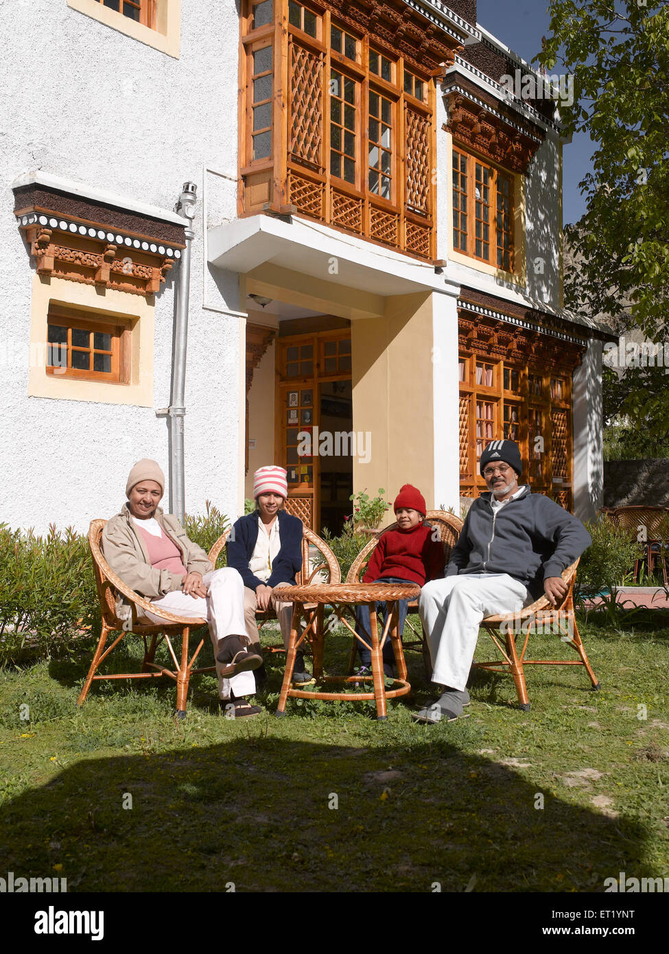 Family sitting in hotel garden Tingmosgang Ladakh Jammu and Kashmir India MR#477 Stock Photo