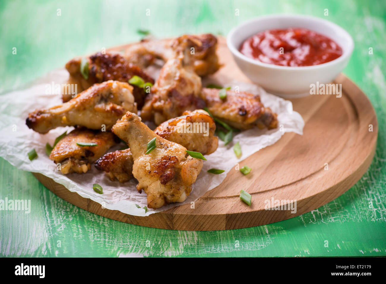 Fried chicken wings with sauces on wooden board, close up, selective focus Stock Photo
