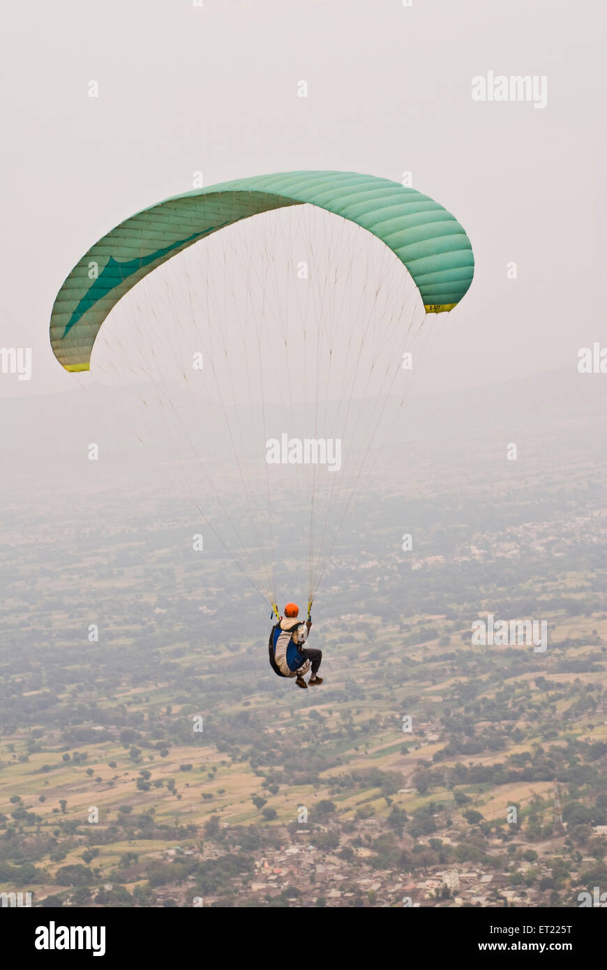 Paraglider paragliding green parachute ; Panchgani ; District Satara ; Maharashtra ; India ; Asia Stock Photo