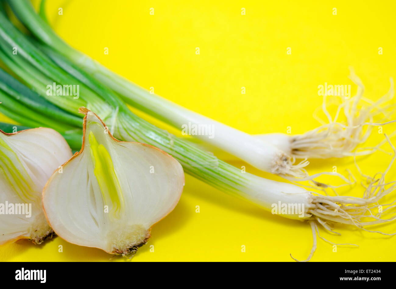 Fresh leek and onions on yellow background Stock Photo