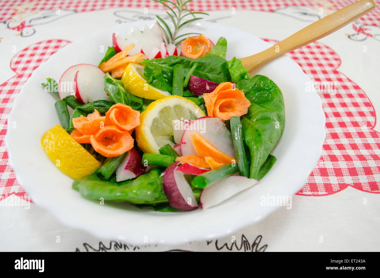 Fresh salad containing lettuce, lemon, carrots, rosemary, onions, radishes, Stock Photo